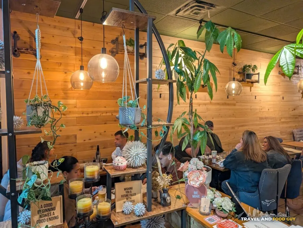 Kaido's dining room with hanging plants, pendant lights and wood plank walls.