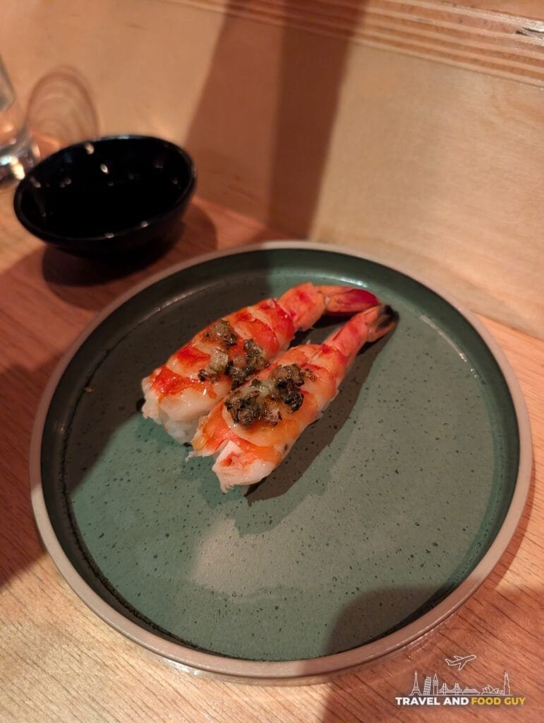 Two big pieces of ebi shrimp nigiri at Sushi-San on a green plate.
