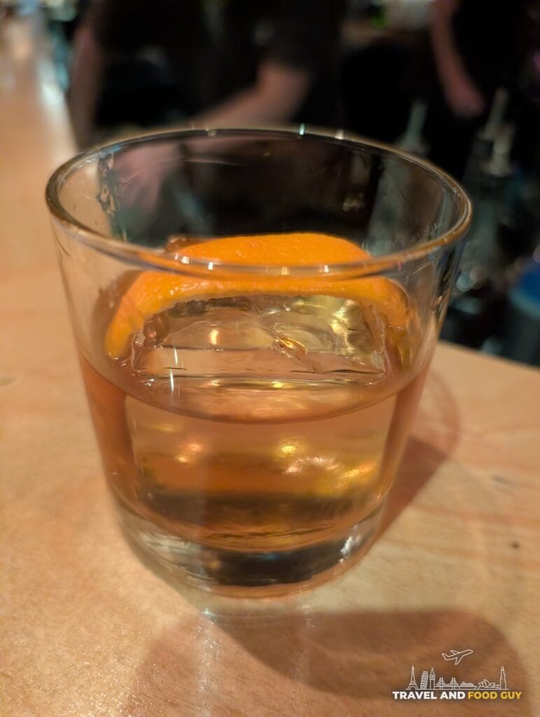 An Old Fashioned with an orange peel over a large ice cube at Sushi-San.