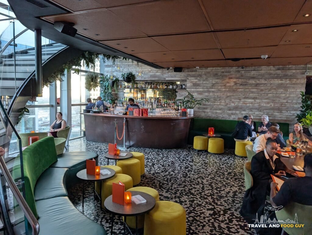 Lounge seating with green banquettes and yellow stools near the bar at SUSHISAMBA London.