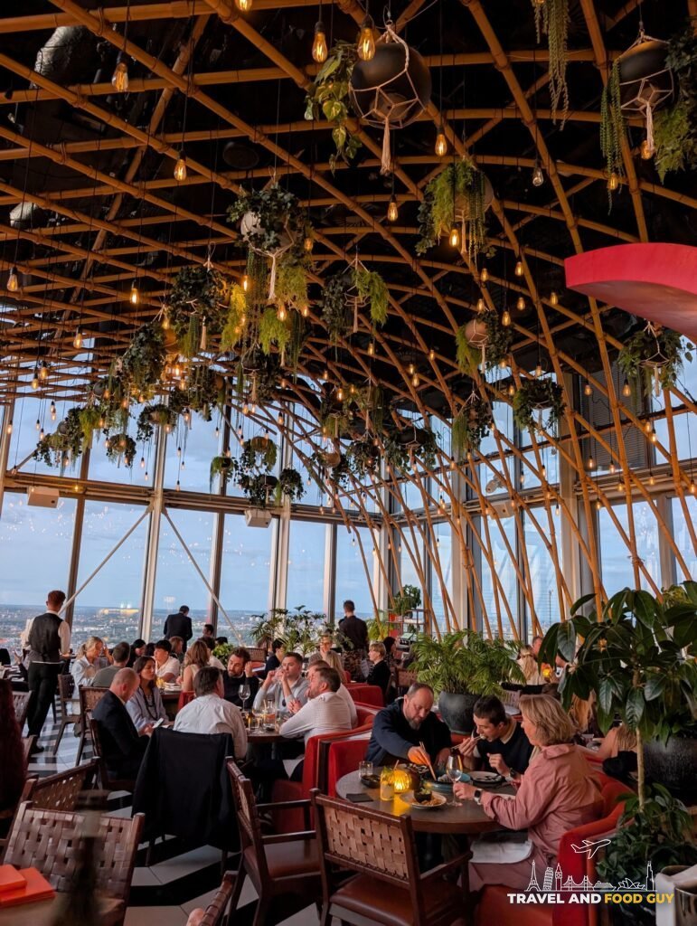 SUSHISAMBA London's main dining room under a tall bamboo lattice ceiling hung with plants and lights.
