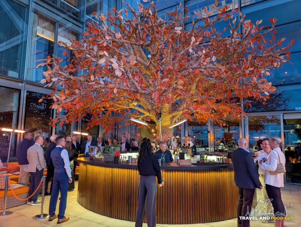 The orange tree sculpture over the terrace bar at SUSHISAMBA London at dusk.