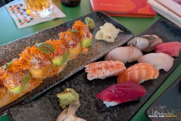 The Samba London roll next to a seven piece nigiri omakase at SUSHISAMBA London, with an Asahi in the background.