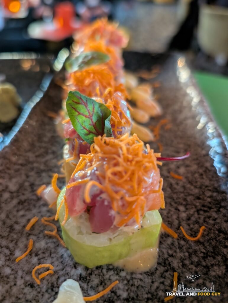 Close up of the Samba London roll at SUSHISAMBA London, topped with crispy shallots and micro greens.