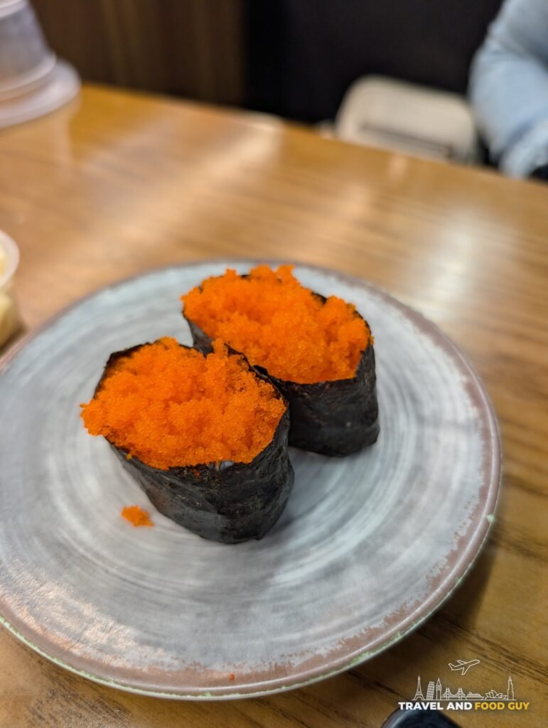 Two pieces of masago gunkan on a gray plate.