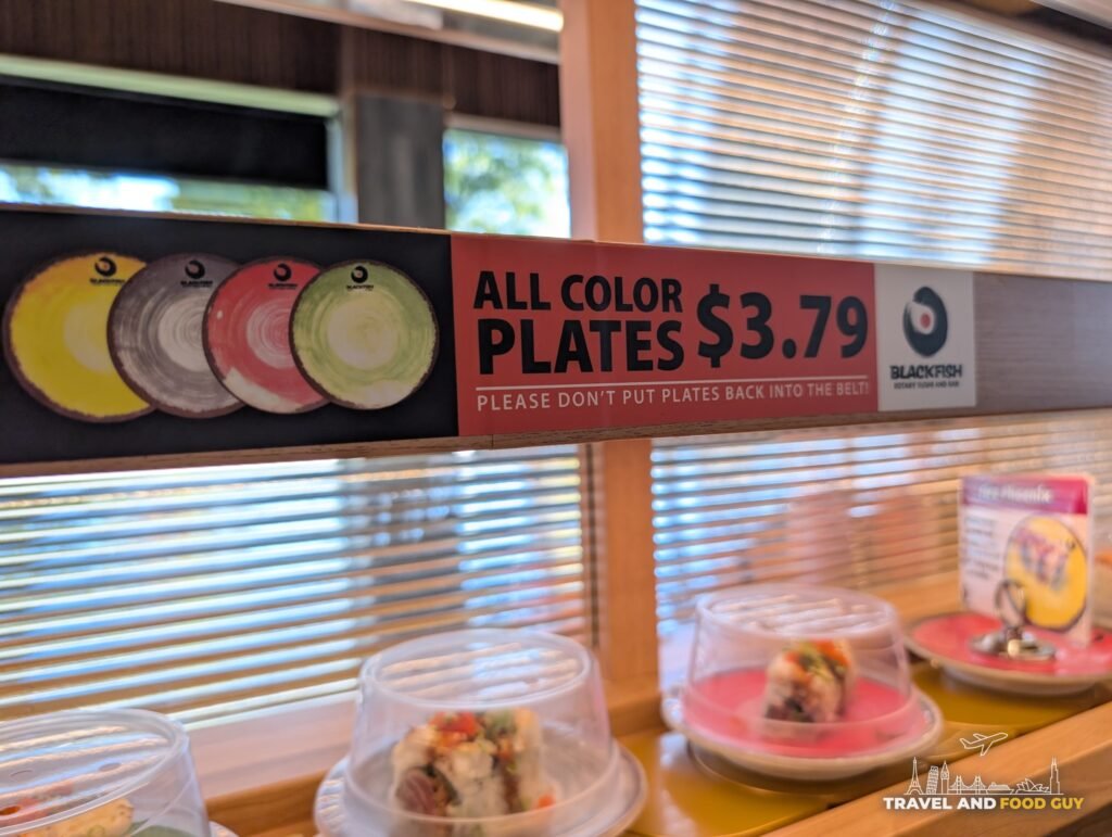 A red sign above the belt at Blackfish that says all color plates $3.79, please don't put plates back into the belt.