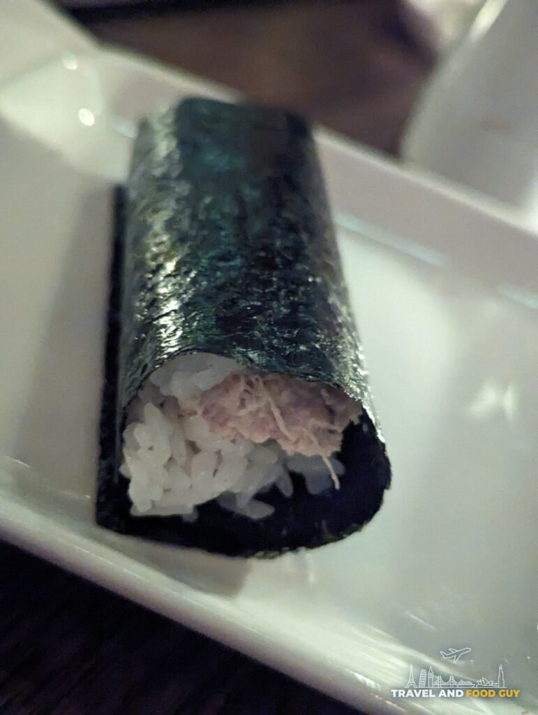 A blue and Dungeness crab hand roll in seaweed showing the rice and crab filling at SUGARFISH Beverly Hills.