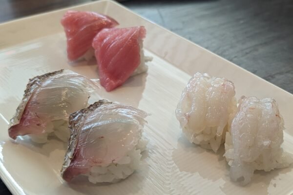 Tuna, sea bream and shrimp nigiri on a white plate at SUGARFISH Beverly Hills during a family lunch.