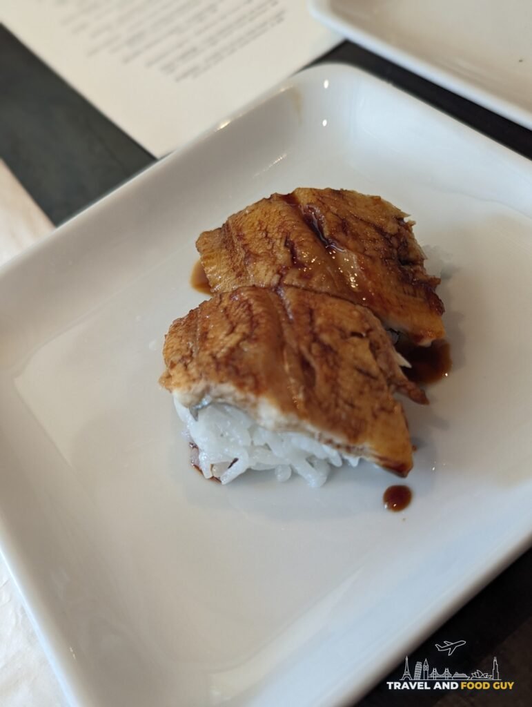 Two pieces of eel nigiri brushed with sauce on a white plate at SUGARFISH Beverly Hills.