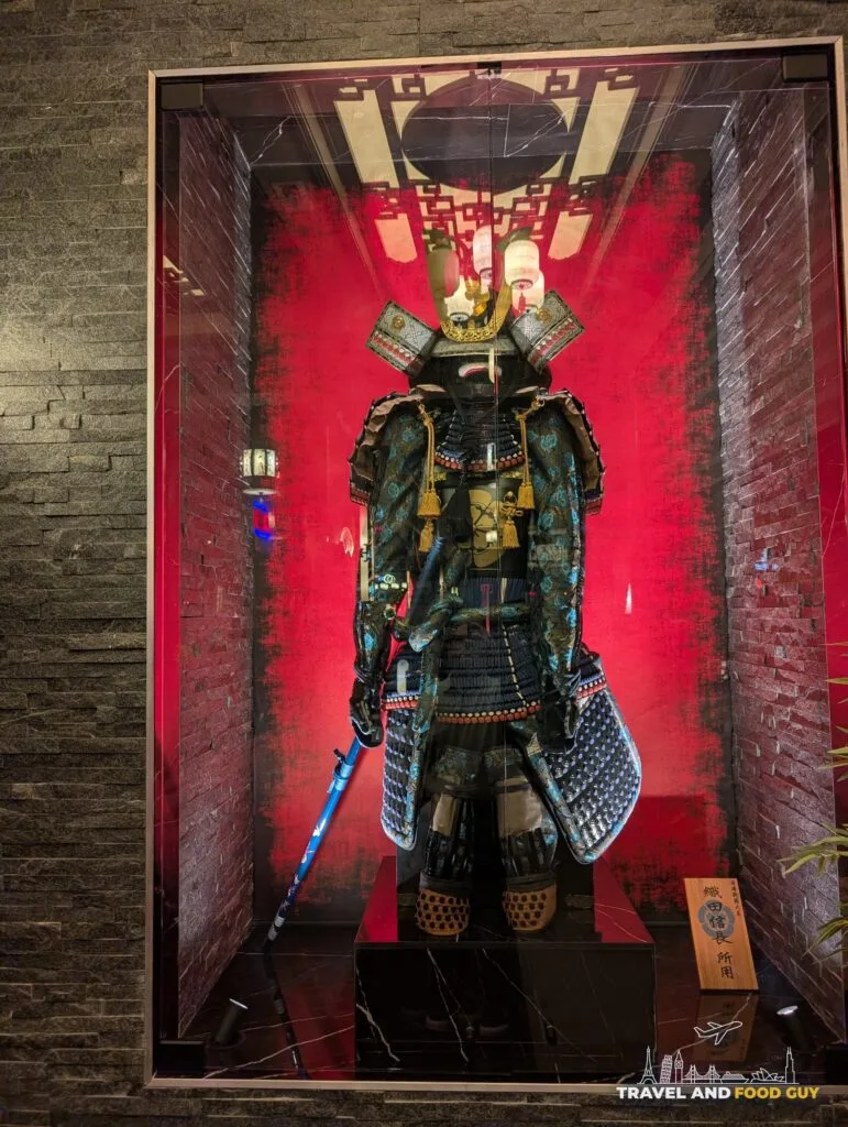 A full suit of samurai armor in a red lit glass case at Wu's House Kildeer.