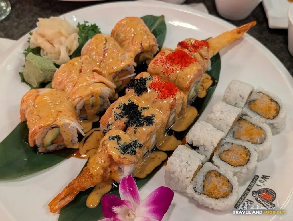 Three sushi rolls on one plate at Wu's House: the SK Bomb, the Black Thunder with black and red tobiko, and a plain spicy scallop roll.