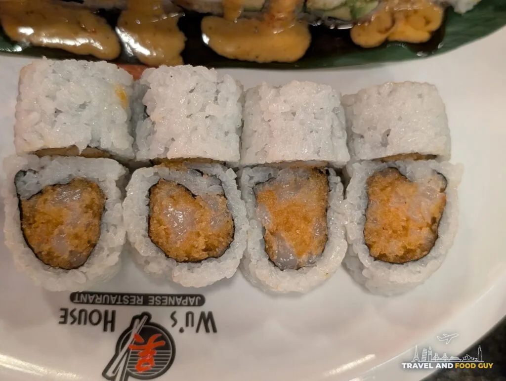 A row of Spicy Scallop Roll pieces at Wu's House Kildeer, rice on the outside and a minced orange filling.